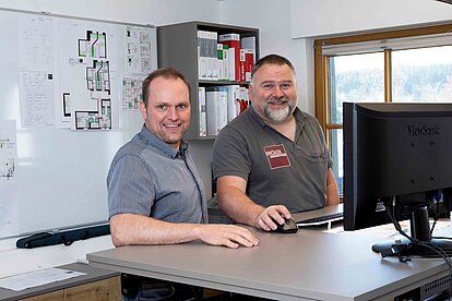 Zwei Mitarbeitende von Bröker Objekteinrichtungen bei der Projektkoordination am Schreibtisch im Planungsbüro